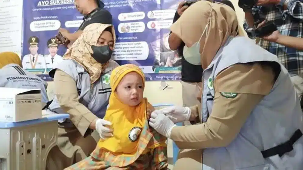 Petugas kesehatan memberi imunisasi pada anak-anak di Sumenep sebagai upaya mencegah penularan campak.