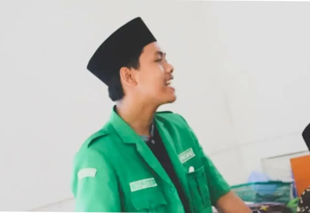 Foto profil Wildan, Wakil Sekretaris Bidang Media Cyber GP Ansor Sumenep, penulis artikel tentang ruang kerja senyap Wakil Bupati Sumenep, tampak mengenakan peci hitam dan seragam hijau.