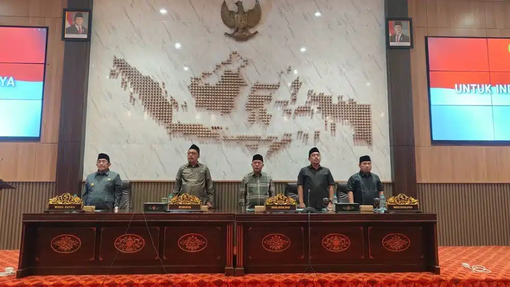 Pimpinan DPRD Sumenep memimpin rapat paripurna penyampaian laporan reses dengan latar belakang dekorasi peta Indonesia.