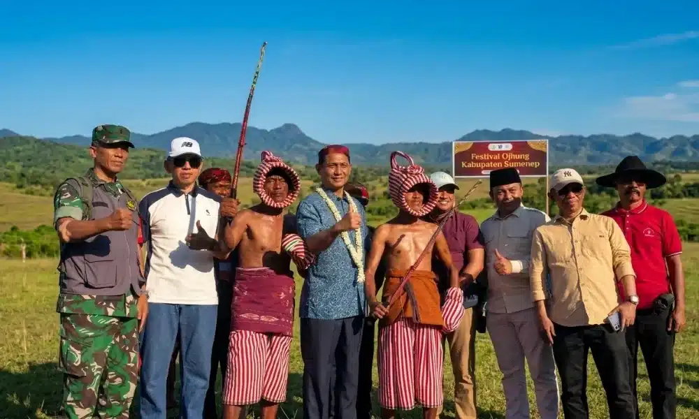 Sekretaris Daerah Sumenep Agus Dwi Saputra bersama jajaran forkopimda dan para pesilat petarung tradisi Ojung berfoto bersama di area terbuka hijau Pantai Galung, Batuputih, Sumenep, dengan latar belakang perbukitan.