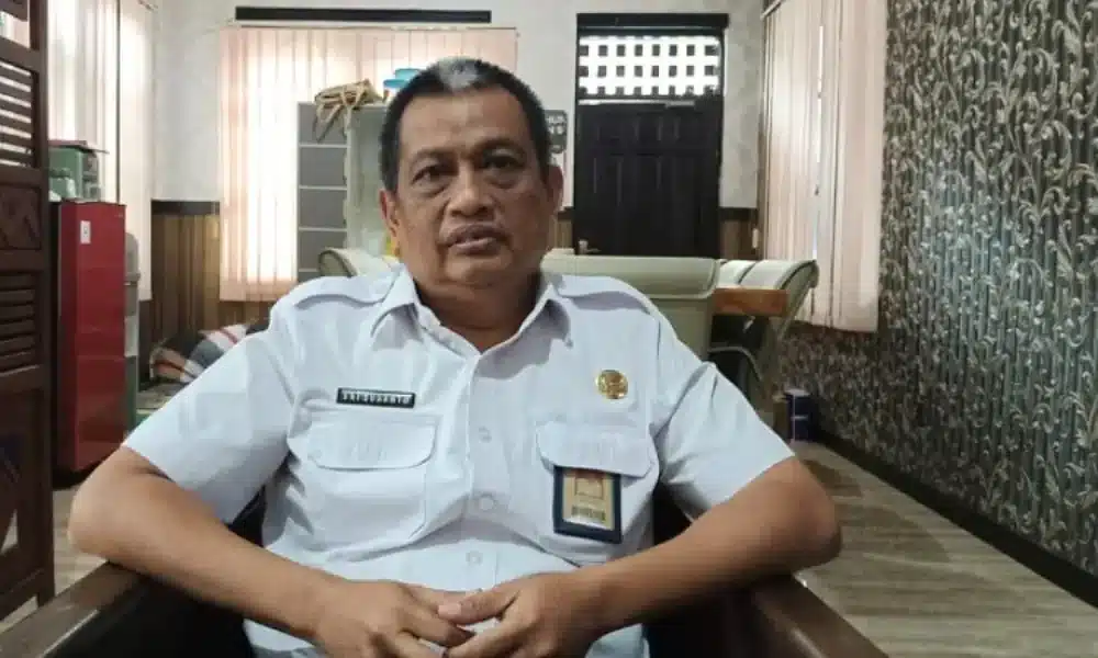 Kepala Dinas PUTR Sumenep, Erie Susanto, duduk di ruang kerjanya, mengenakan seragam resmi dengan tanda pengenal.