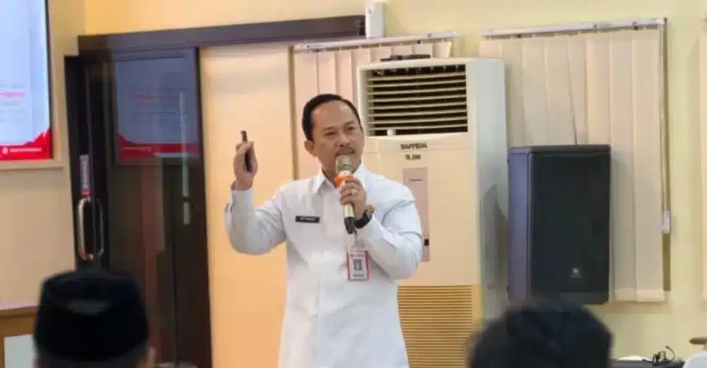Kepala Bappeda Sumenep, Arif Firmanto, berdiri memberikan pemaparan di depan forum diskusi menggunakan mikrofon, sebagai bagian dari upaya Pemkab dalam memperkuat stabilitas sosial politik demi pembangunan berkelanjutan.